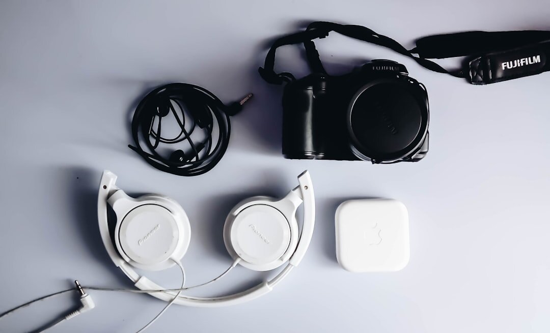 Flat lay of filmmaking equipment including a mirrorless camera, lenses, microphone and headphones